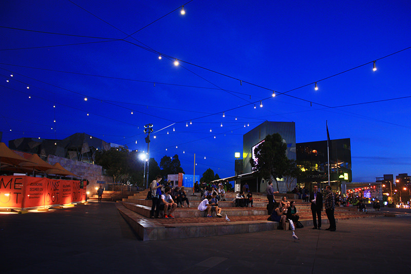 People gathering at Flinders Square covered with catenary downlights